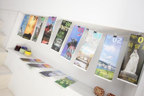 a row of posters on a white wall at Casa Blanca Guesthouse in Nagasaki