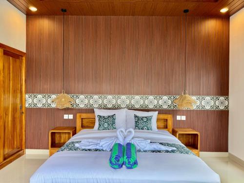 a bedroom with a bed with green shoes on it at Moonlight Heaven Villa Ubud 2BR Private Pool in Tampaksiring