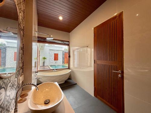 a bathroom with a sink and a toilet and a tub at Moonlight Heaven Villa Ubud 2BR Private Pool in Tampaksiring