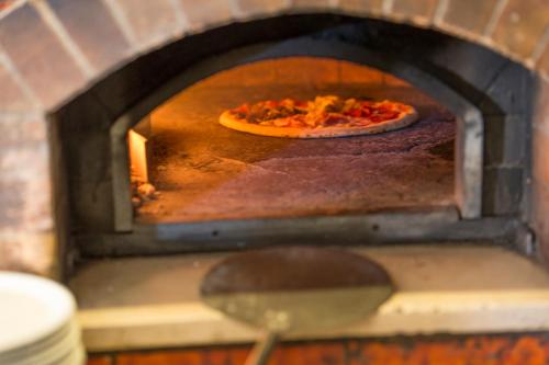 a pizza is cooking in a brick oven at Hotel Chalet Olympia in Monguelfo