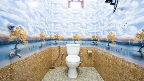 a bathroom with a toilet and a painting of ducks at Near Town Lodge in Dambulla