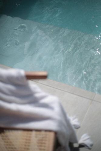a person sitting in a chair next to a swimming pool at La La Villas in Pulau Pototogat