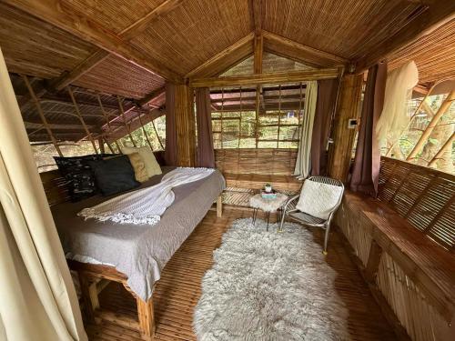 a bedroom with a bed and a chair in a room at Hangin at Agos Resort in Nasugbu