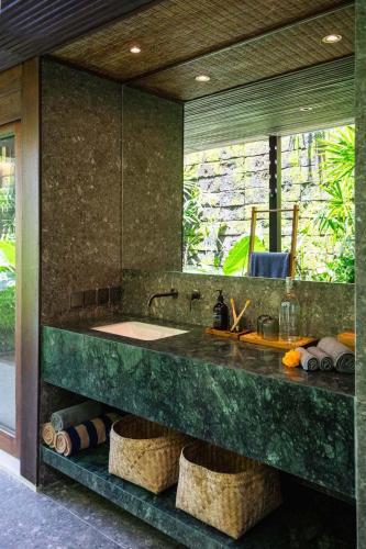 a bathroom with a sink and a mirror at Sejati Boutique Hotel Uluwatu in Uluwatu
