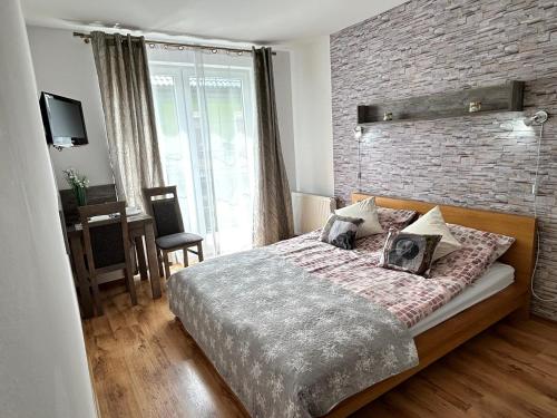 a bedroom with a large bed and a brick wall at Villa Over Lake in Mielno