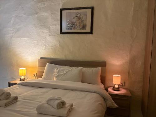 a bedroom with towels on a bed with two lamps at Guesthouse 39 in Mqabba
