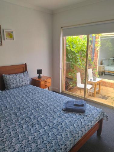 a bedroom with a bed and a view of a patio at Comfort and good value in Melton South