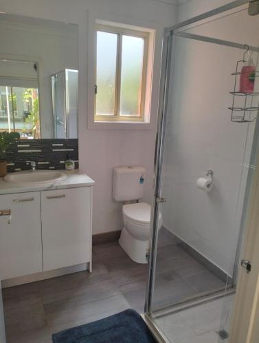 a bathroom with a toilet and a glass shower at Comfort and good value in Melton South