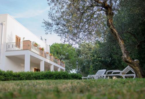 two white chairs sitting in front of a building at Il Delfino in Pisticci