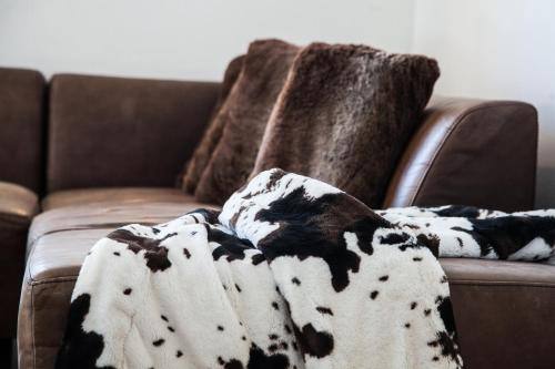 a brown couch with a blanket on it at Ferienhaus Alex in Wiesing