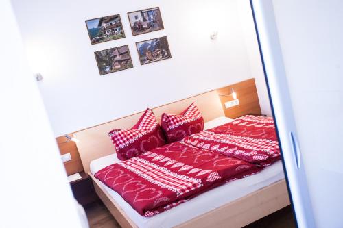 a bedroom with a bed with red and white pillows at Ferienhaus Alex in Wiesing