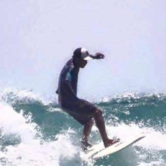 a man riding a wave on a surfboard in the ocean at Fideluna Beach Bungalow in Insyurifuri