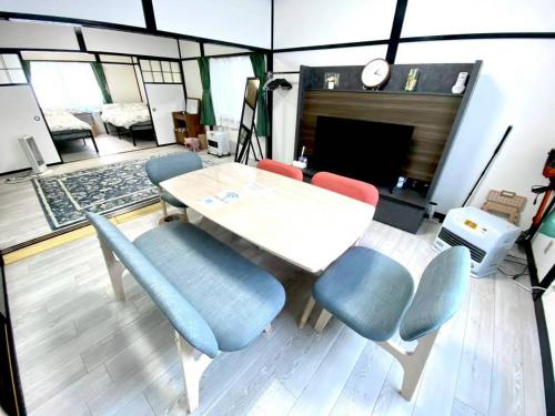 a table and chairs in a room with a fireplace at comodo inn HANAZONO in Aomori