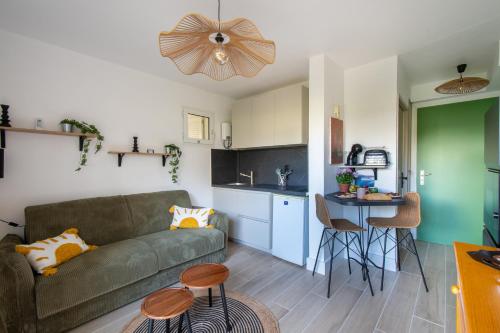a living room with a couch and a kitchen at Jardin du Golf wifi Clim in La Grande Motte