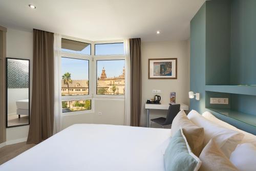 a bedroom with a large bed and a window at Hotel Pasarela in Seville