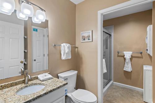 a bathroom with a toilet and a sink and a mirror at Windancer 110 in Destin