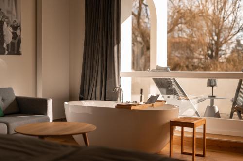 a living room with a bath tub and a window at Das Parkhotel - Südtirols nördlichster Punkt in Bad Wörishofen