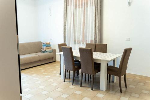 a dining room with a table and chairs and a couch at Casa Solemare Strongoli in Marina di Strongoli
