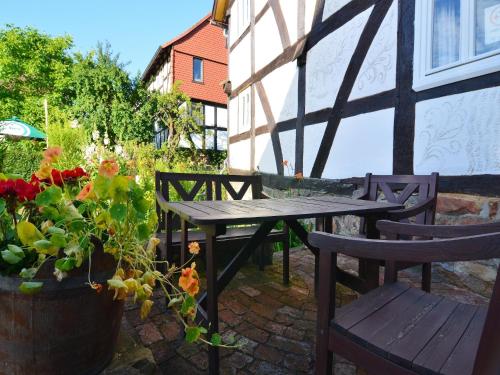 a patio with a table and chairs and a potted plant at Traditionelles Ferienhaus in Hessen mit Garten in Willingshausen