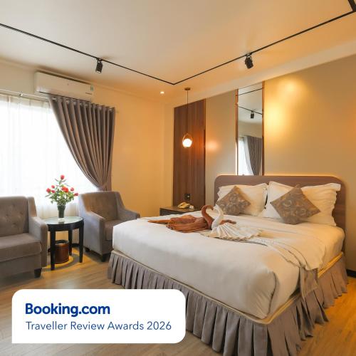 a bedroom with a large bed and a chair at Rosaleen Boutique Hotel in Hue