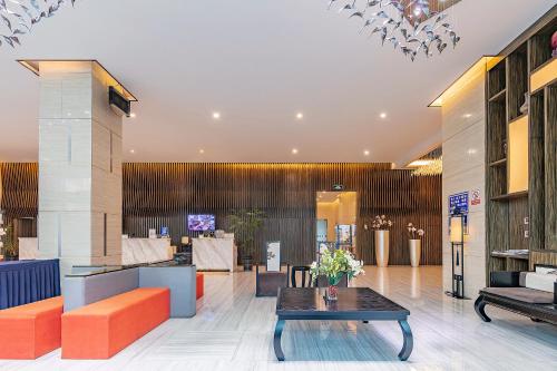 a lobby with orange and blue furniture and a table at Yihe Hotel Luoyang in Luoyang