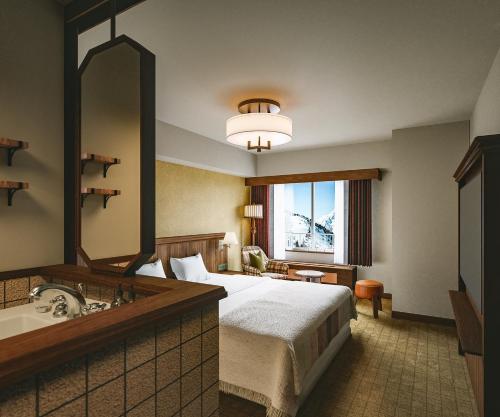 a hotel room with a bed and a sink and a mirror at The Alps Hotel Hakuba in Otari