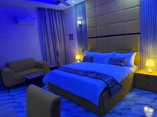 a bedroom with a king sized bed and a chair at Unique CityLife Hotel in Etoi
