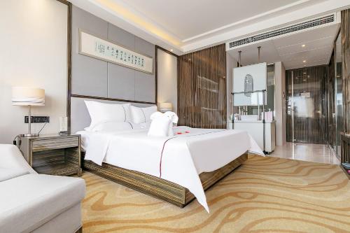 a bedroom with a large white bed and a couch at Yihe Hotel Luoyang in Luoyang