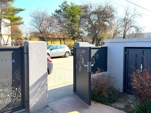 a pair of gates in a parking lot with a car at Aurora Premium Home in Győr