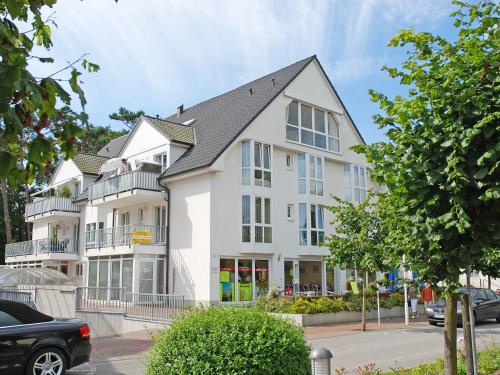 a white building with a black roof at Fewo Strandallee - Baabe in Baabe