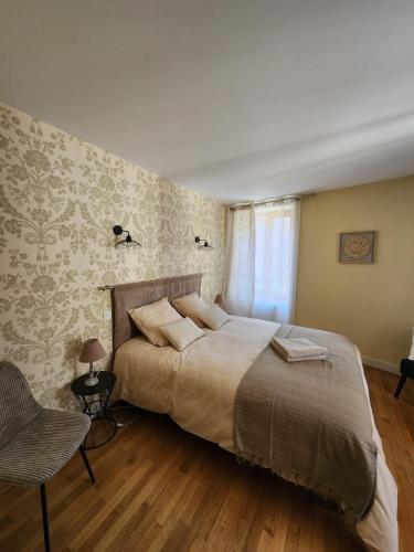 a bedroom with a large bed and a chair at La Tour Cicon in Salins-les-Bains