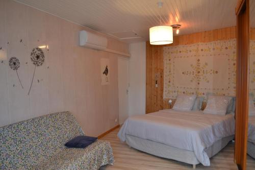 a bedroom with two beds and a couch in it at studio indépendant dans maison à la campagne in Égliseneuve-près-Billom