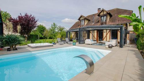 una piscina di fronte a una casa di La Villa Séquoia a Les Bordes-Aumont