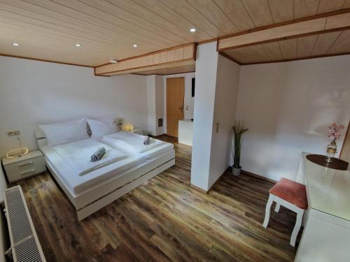 ein Schlafzimmer mit einem weißen Bett und einer Holzdecke in der Unterkunft Pfaffenhaus in Frankenheim