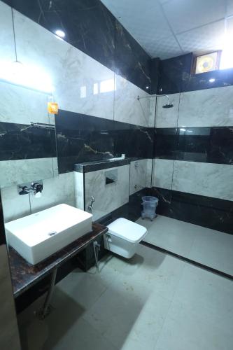 a bathroom with a sink and a toilet at Corbett Caves in Rāmnagar