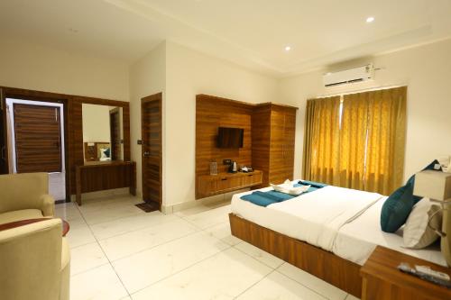 a bedroom with a large bed and a television at Corbett Caves in Rāmnagar