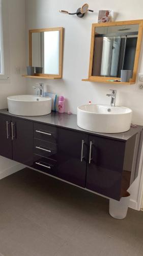 a bathroom with two sinks and a mirror at Tardif in Vitré