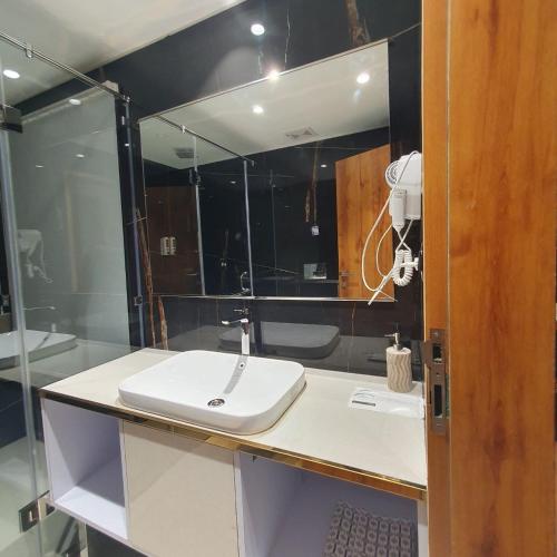 a bathroom with a sink and a mirror at Dallas Beach Resorts Ashvem Beach in Mandrem