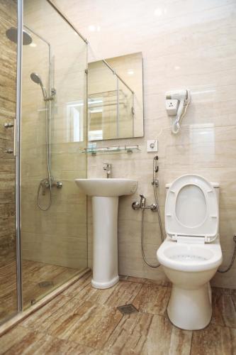 ein Badezimmer mit Toilette, Waschbecken und Dusche in der Unterkunft MidCity Hotel in Baku