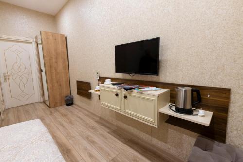 ein Hotelzimmer mit einem Flachbildfernseher an der Wand in der Unterkunft MidCity Hotel in Baku