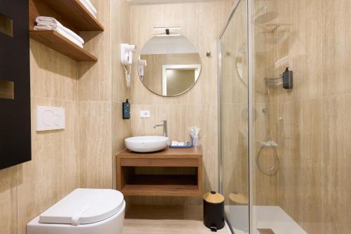 a bathroom with a toilet and a sink and a shower at Best Western Hotel Continental in Udine