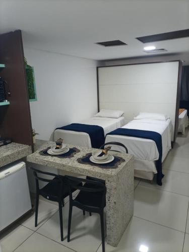 a hotel room with two beds and a table and chairs at Ocean Flat Tambaú in João Pessoa