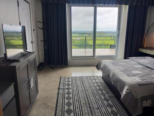 a bedroom with a bed and a large window at Before Sunrise Terrace Villa 270° Natural View Chiang Rai in Ban Pa Tung (7)