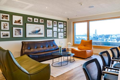 a living room with a leather couch and chairs at Brera Meckenbeuren-Friedrichshafen in Meckenbeuren