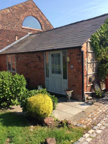 a brick house with a door and a window at The Barn Bed and Breakfast in Liverpool