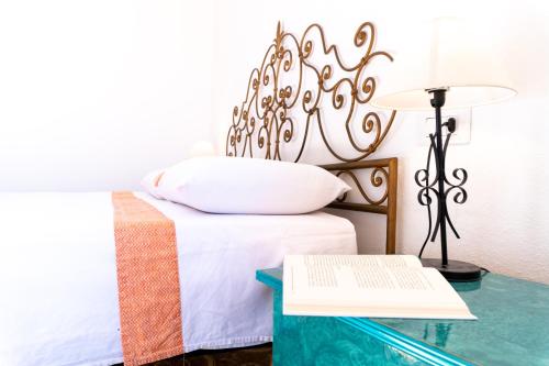 a bedroom with a bed and a table with a book at Casa Ombrina in Orosei