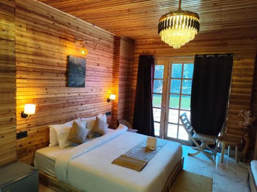 a bedroom with a large bed and a window at Pradhan Hotel Mirik Lake Side in Mirik
