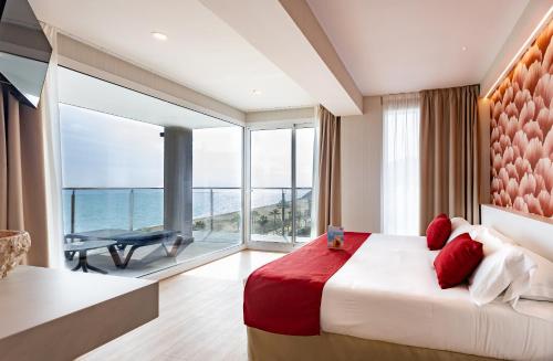 a bedroom with a large bed with a view of the ocean at Hotel Internacional in Calella