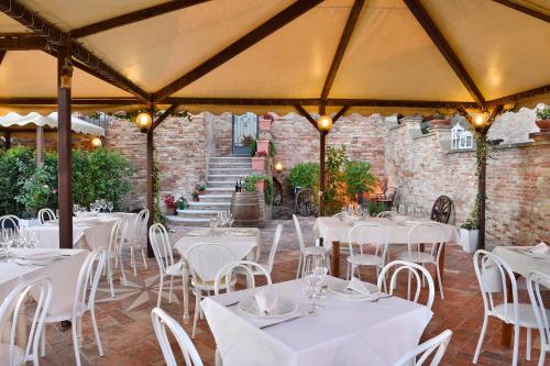 a dining room with white tables and chairs at Albergo Diffuso Borgo Montemaggiore in Montemaggiore al Metauro