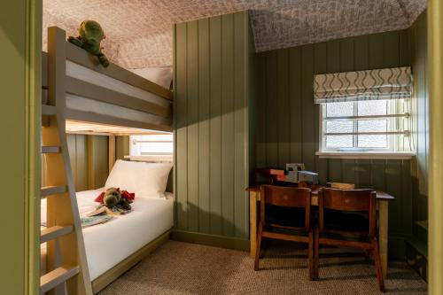 a bedroom with a bunk bed and a table and a desk at Bel and The Dragon-Cookham in Cookham